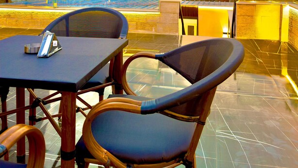A table and chairs on a rooftop terrace with a view of the pyramids at sunset. -  Pyramids Enigma Grand Lodge (Giza)