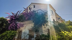 Un bâtiment doté d’une tour imposante, d’un escalier en métal et entouré de verdure.