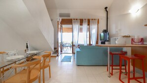 A modern kitchen with a dining area, a TV, and a sofa. - 2 bedroom cozy home in Is Molas (Is Molas)