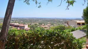 A hillside residential area with houses, a view of the distant landscape, and a tree in the foreground. - 2 bedroom cozy home in Is Molas (Is Molas)