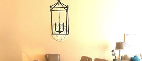 A dining area with a dark wooden table, six chairs, and a hanging lantern.