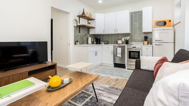 A modern apartment with a living room, a kitchen, and a dining area. - Mockingbird Bungalow min to beaches (Gulfport)