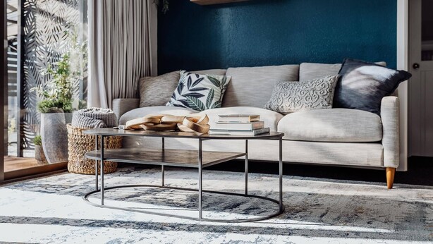 Ein Wohnzimmer mit einer Couch, einem Couchtisch und dekorativen Kissen.