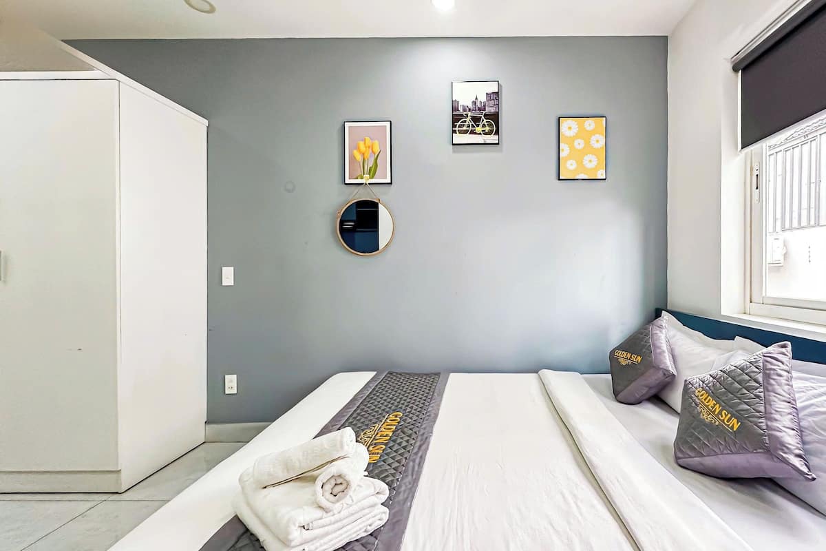Ein modernes Schlafzimmer mit einem Bett, einem runden Spiegel und zwei gerahmten Bildern an der Wand.