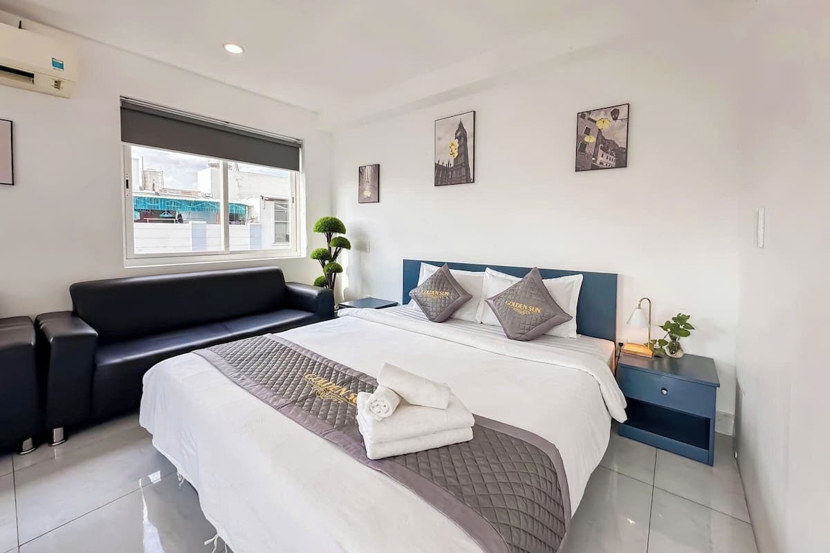 Ein modernes Hotelzimmer mit Bett, einer Sitzecke, einem Fenster mit Blick und Kunstwerken an den Wänden.