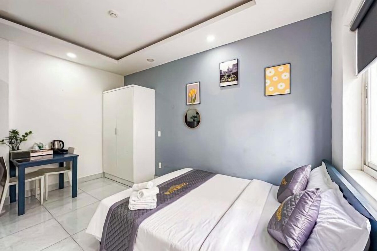 Una habitación de hotel moderna con cama, escritorio y armario.