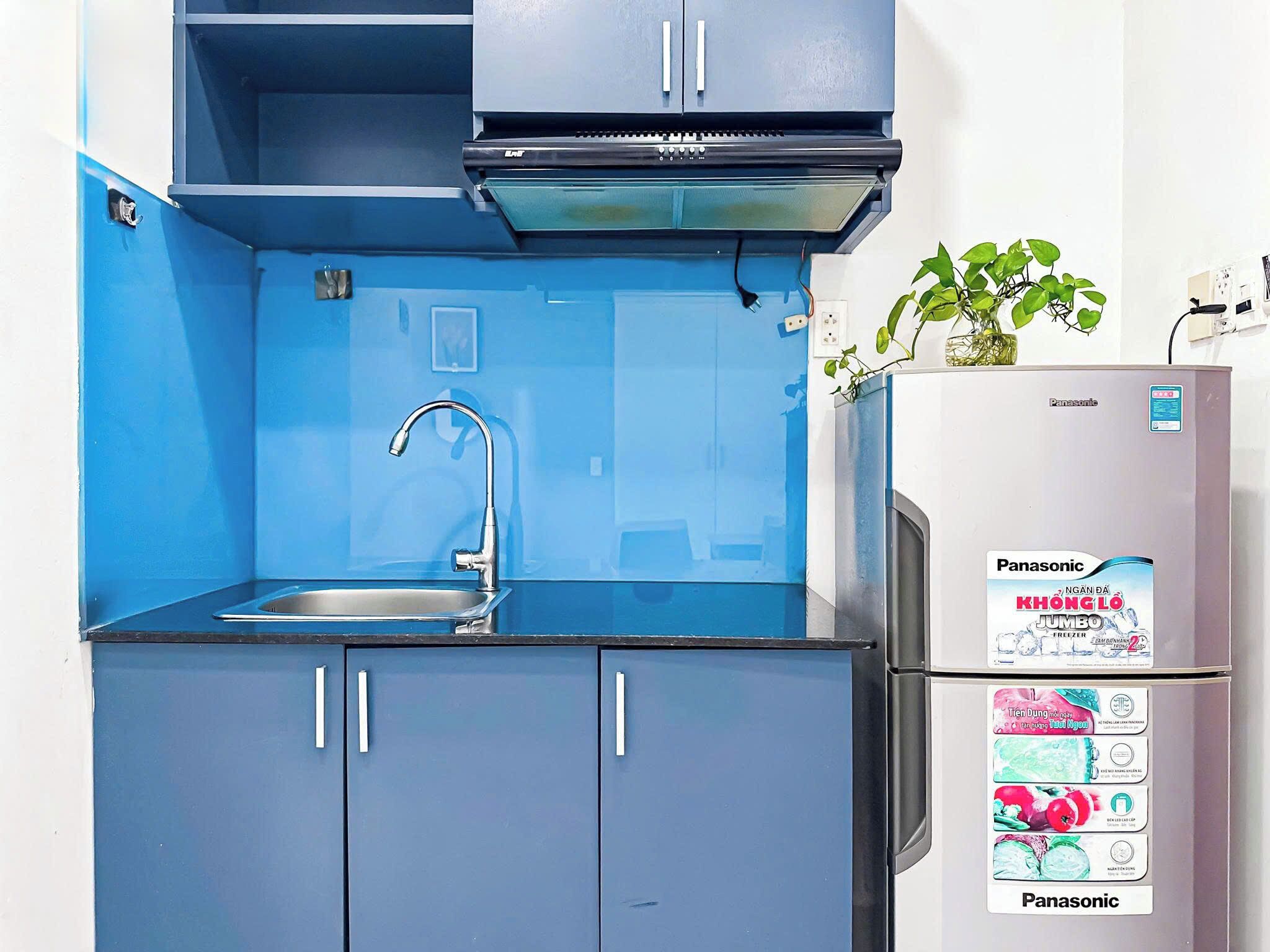 A compact kitchen with a sink, cabinets, a stove, and a refrigerator.