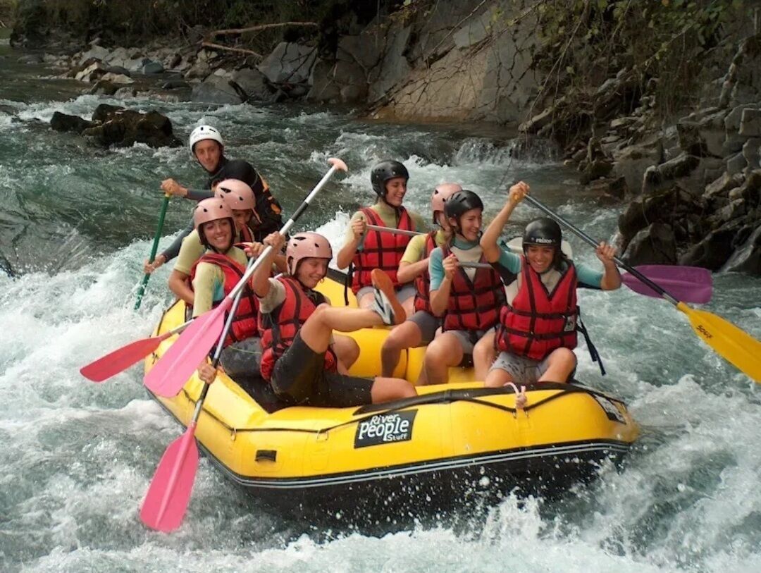 Een groep mensen in een gele luchtbed op een rivier.
