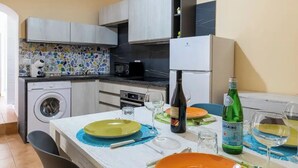 Eine moderne Küche mit Essbereich, einer Waschmaschine und einem Kühlschrank.