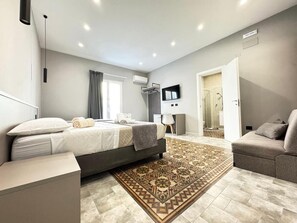 Deluxe vierpersoonskamer | Bedden met traagschuimmatrassen, een minibar, een bureau