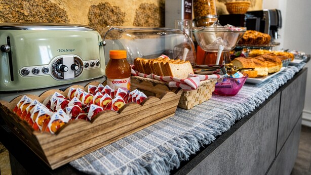 Ein Frühstücksbuffet mit verschiedenen Speisen, einem alten Toaster und einer Kaffeemaschine.