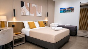 Ein modernes Hotelzimmer mit einem großen Bett, Nachttischen, einem Sessel und Bildern an den Wänden.