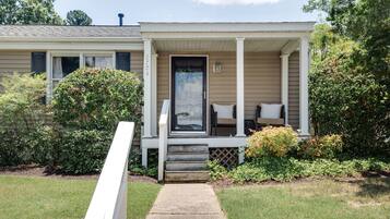 A single-story house with a front porch, a mailbox, and a small garden area.