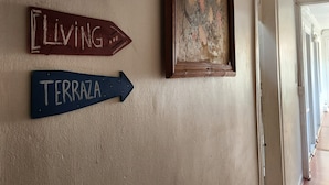 A hallway with a sign pointing to 'Living' and another to 'Terraza'. - La Casa Piola (Valparaiso)