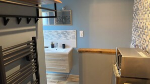 A modern kitchen with a built-in oven, a stainless steel refrigerator, and a wooden countertop.