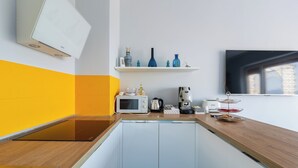 A compact kitchen with a microwave, coffee maker, and a small shelf with decorative items. - Relais Mirage Sorrento (Sorrento)