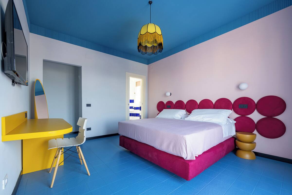 Een moderne slaapkamer met een bed, een bureau en een stoel.