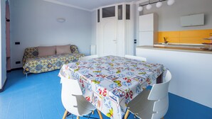 A compact living space with a dining area, two beds, a kitchenette, and a bathroom. - Relais Mirage Sorrento (Sorrento)