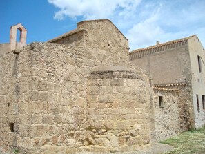 Explore the historic architecture of this ancient building, featuring a grand arched doorway and a bell tower.