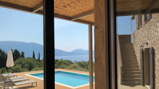 A modern villa with a pool, wooden deck, and a view of mountains. - Evreti DREAMHOUSE Stone House With Private Pool & Sea View. A Paradise on Earth! (CHMJ+HVW Evreti, Greece)