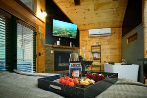 A cozy room with a television, fireplace, and a tray of snacks.