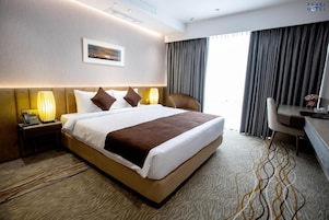 Una habitación de hotel con una cama grande, un escritorio y una silla.