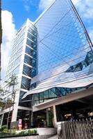 Um hotel moderno com fachada de vidro e entrada imponente.