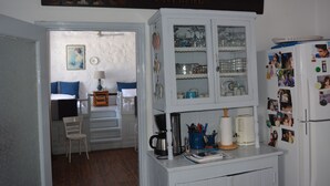 Eine Küche mit einem weißen Schrank, einer Kaffeemaschine und einem Kühlschrank mit Fotos.