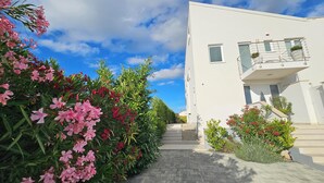 A modern building with a white facade, a balcony with a metal railing, and a clear sky. - Apartments with Shared Pool Casa Bianca (Kanfanar)