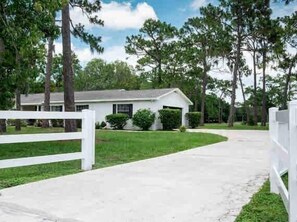 A single-story house with a white exterior, a front porch, and a driveway leading to the entrance. - 2 separate homes, each 3-bed 2 bath one on Lake and are only a 5-min. car ride. (Lutz)