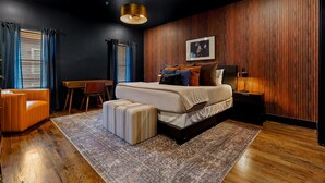 Een moderne slaapkamer met een groot bed, een bureau en een stoel.
