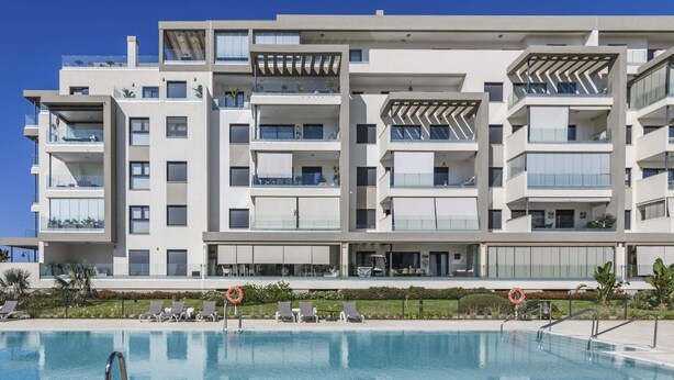 Un hôtel moderne à plusieurs étages, doté d’une piscine, de balcons et d’espaces de détente en plein air.