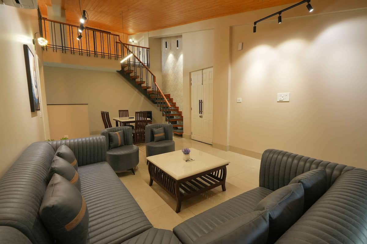 A spacious living area with a staircase, sofas, and a coffee table.