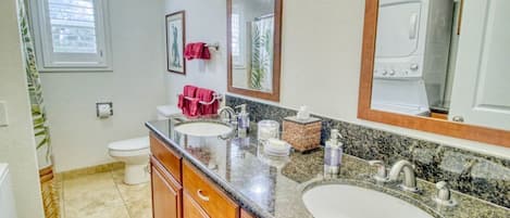 A bathroom with two sinks, a toilet, and a shower.
