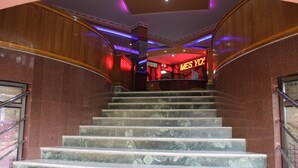 A marble staircase leading to a lobby with a neon sign reading "MES YO". - Gokul Plaza (Bhubaneshwar)