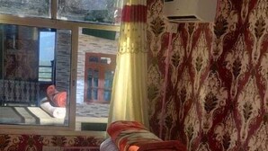 A room with a bed, a window with curtains, and patterned wallpaper. - SS Hotel Kings & Lodge Charikot Dolakha (Bhimeshwar)