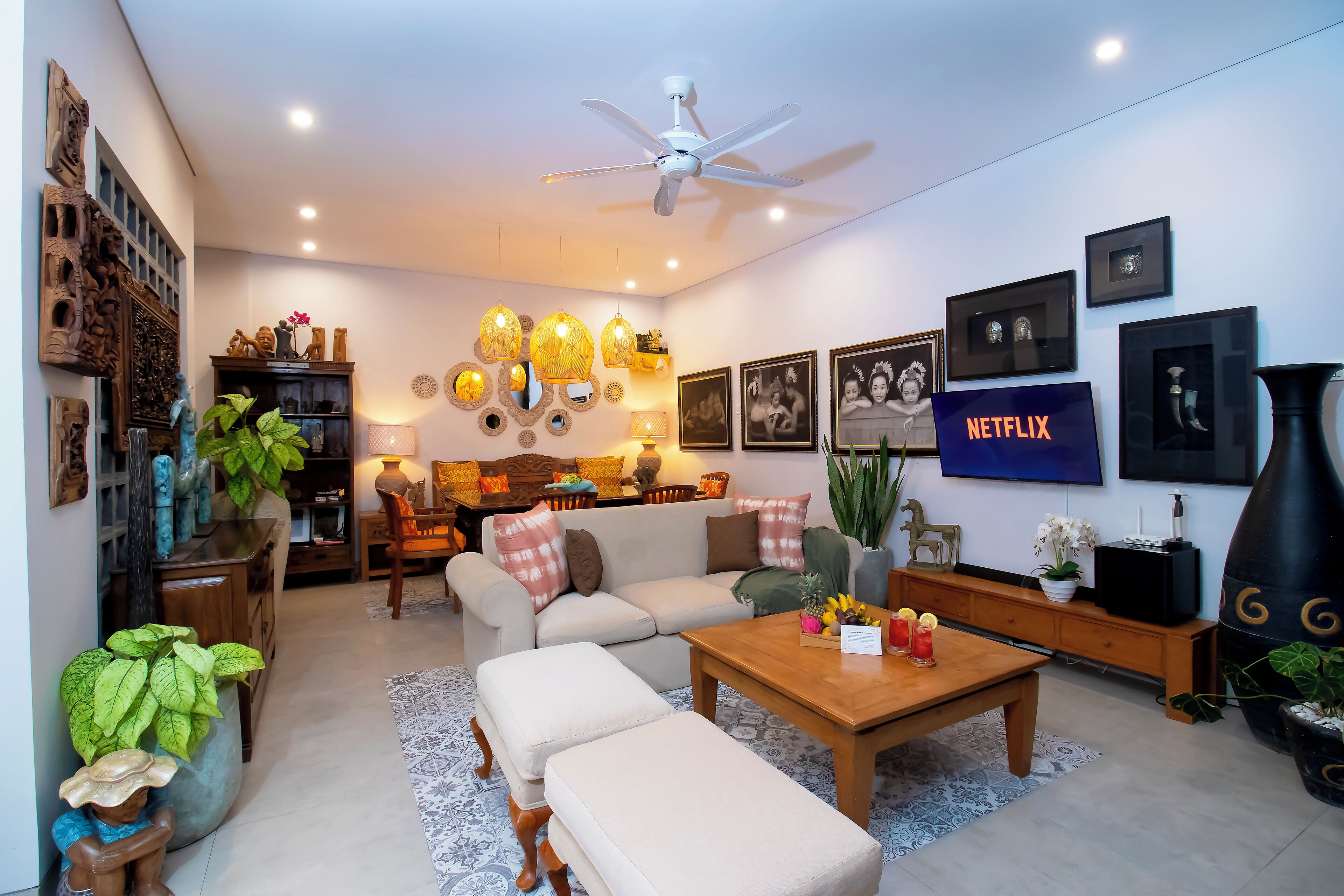 A modern living room with a sofa, coffee table, and a TV displaying the Netflix logo.