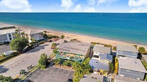 Ein Küstenhotel mit Blick auf den Strand, mehreren Gebäuden und einem Parkplatz.