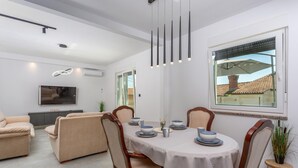 Un espace repas moderne avec une table ronde, des chaises et une vue sur l’extérieur.