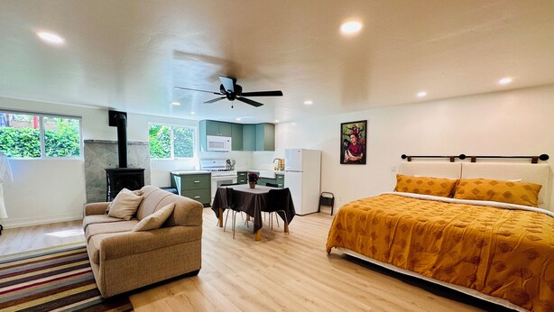 A modern bedroom with a bed, a sofa, a dining table, and a kitchen area. - Cozy studio in adorable Nevada City with AC, WiFi (Nevada City)