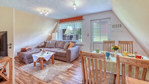 A cozy living room with a sofa, coffee table, and dining table set up. - Cozy home in Dabel with WiFi (Dabel)