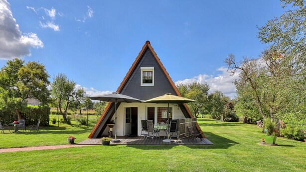 A triangular house with a small porch and a table with chairs. - Cozy home in Dabel with WiFi (Dabel)