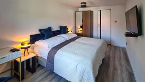 Une chambre moderne avec un grand lit, des lampes de chevet, un bureau et une armoire.