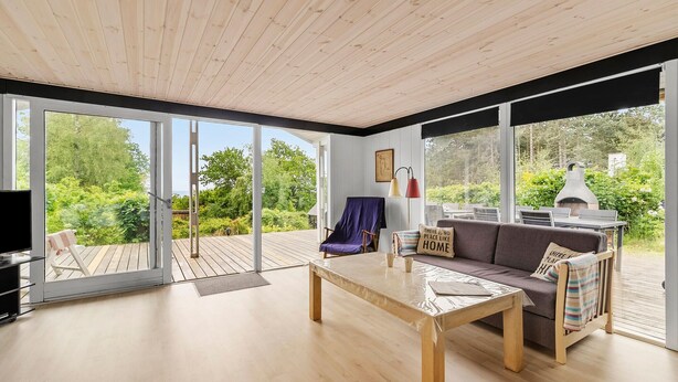 Un salón espacioso con suelo de madera, un sofá, una mesa de centro y una chimenea.