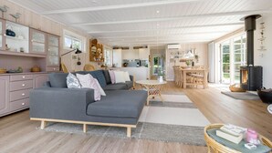 A spacious living room with a grey sofa, wooden flooring, and a large window. - Amazing home in Ebeltoft with WiFi (Ebeltoft)
