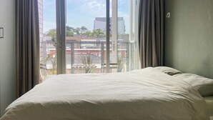 A bed with a striped bedspread in a room with large windows.