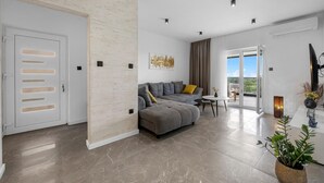 Un salón moderno con un sofá gris, una mesita redonda y una planta en maceta.
