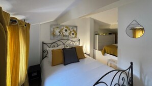 A bedroom with a bed, a nightstand, a mirror, and a painting on the wall. - Villa Club Portissol (Sanary-sur-Mer)