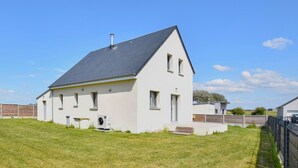 A single-story house with a sloped roof, a small front porch, and a fenced yard. - 3 bedroom awesome home in Créances (Créances)