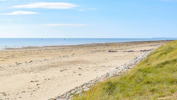 A wide sandy beach with a rocky shoreline, a clear sky, and a distant view of the sea. - 3 bedroom awesome home in Créances (Créances)